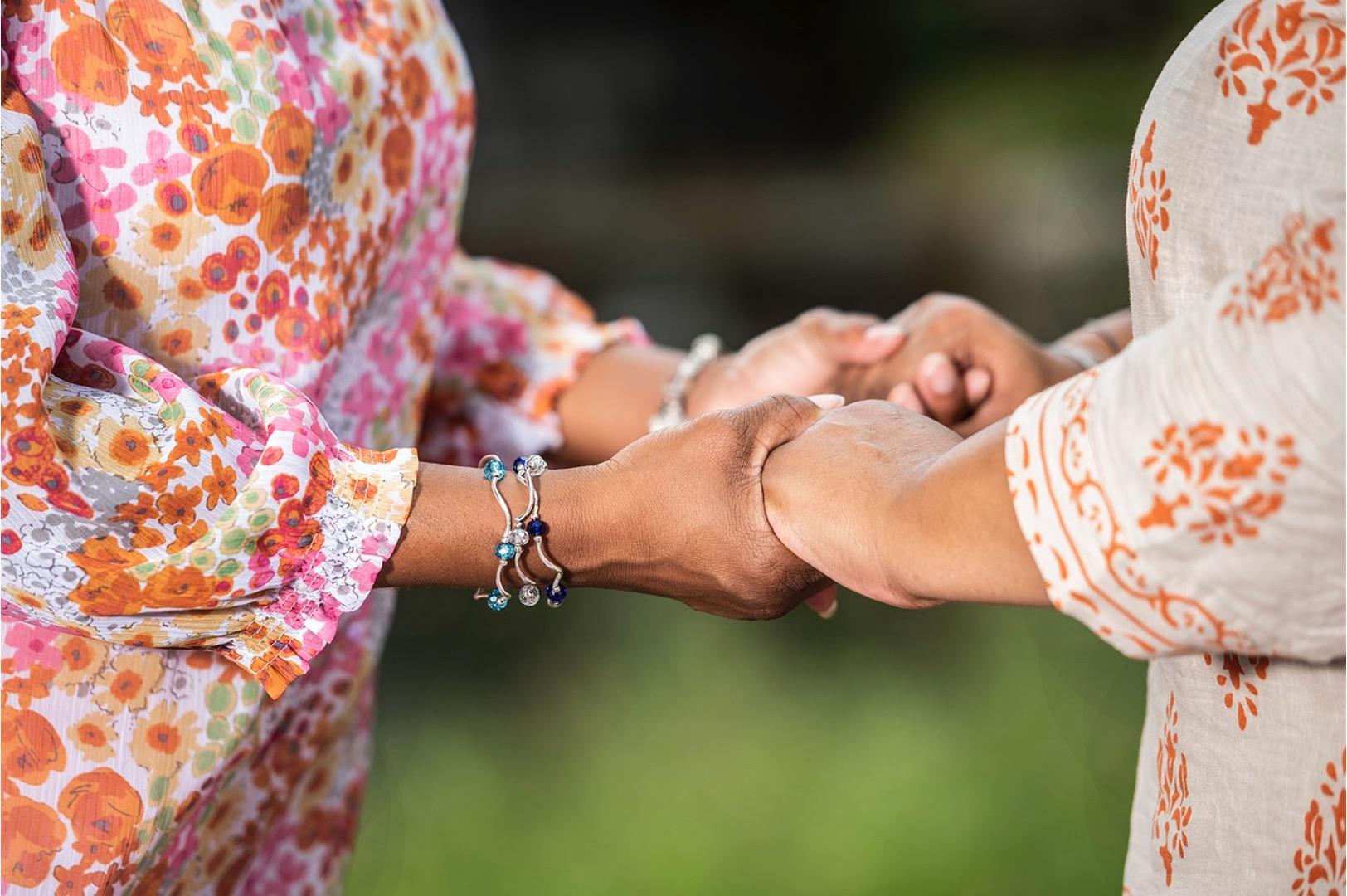 Two women holding hands to encourage each other